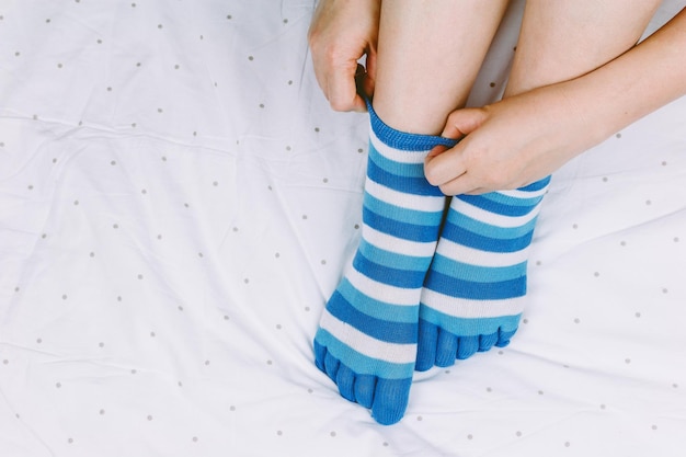 Sección baja de una mujer con calcetines en la cama