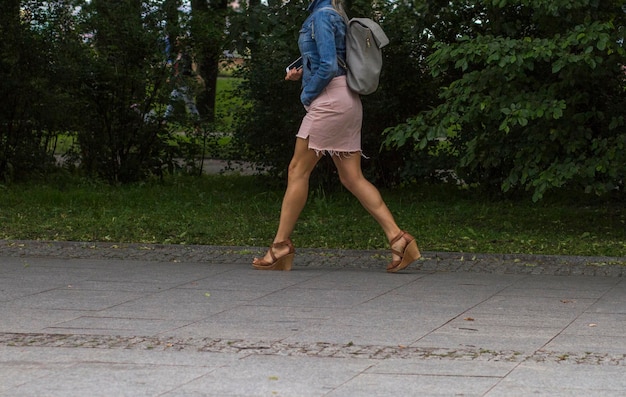 Foto sección baja de una mujer caminando por la carretera