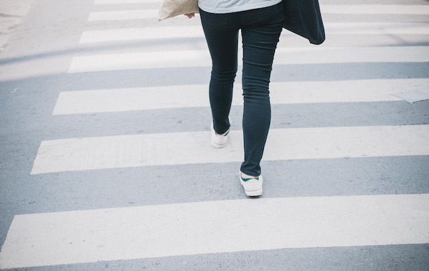 Foto sección baja de una mujer caminando por la carretera