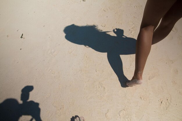 Foto sección baja de una mujer caminando por la playa