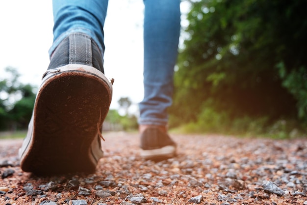 Foto sección baja de una mujer caminando sobre piedras contra el cielo