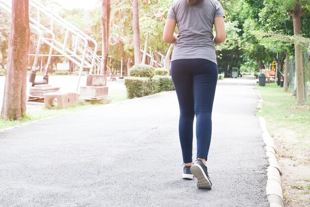 Sección baja de una mujer corriendo por la carretera