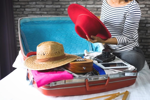 Sección baja de una mujer empacando equipaje en casa