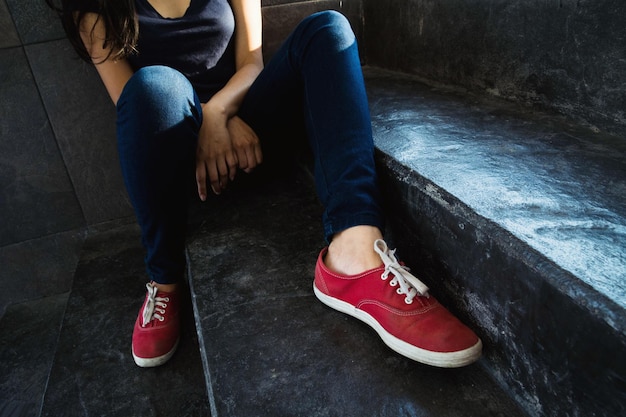 Foto sección baja de una mujer joven sentada en la escalera