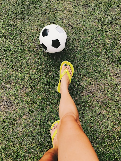 Foto sección baja de una mujer jugando al fútbol en el campo