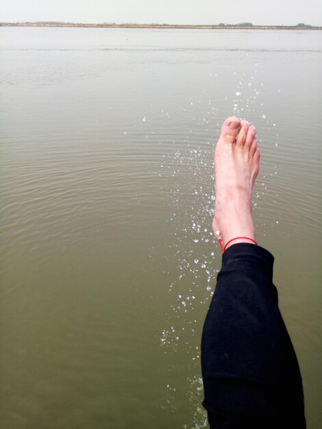 Foto sección baja de la mujer por el lago