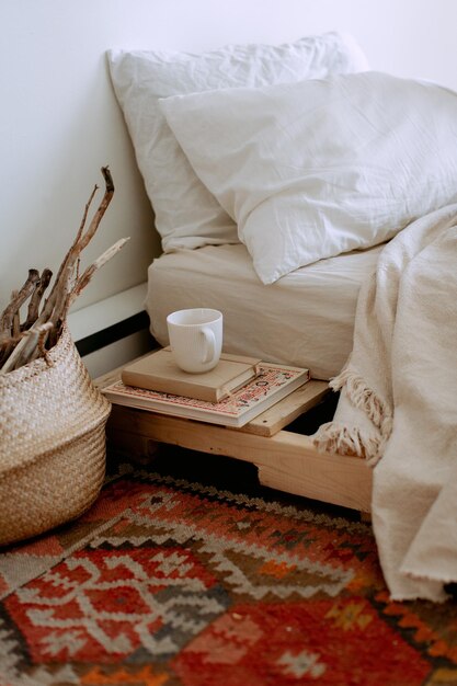 Sección baja de una mujer leyendo un libro en la cama en casa.