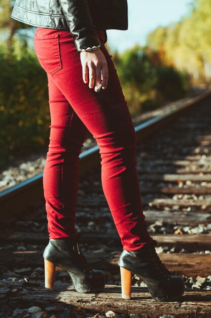 Foto sección baja de una mujer de pie en una corbata de ferrocarril