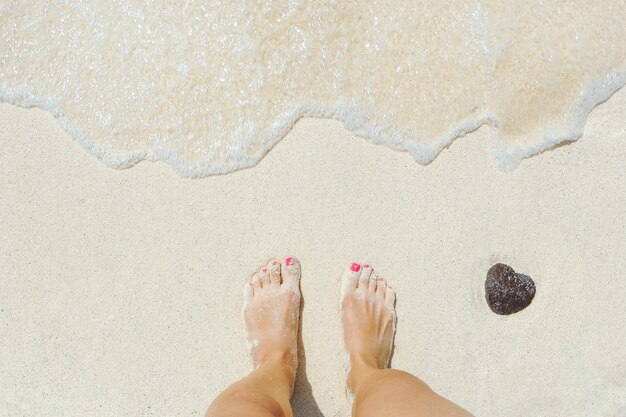 Foto sección baja de una mujer de pie en la playa