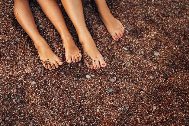 Foto sección baja de una mujer de pie en la playa