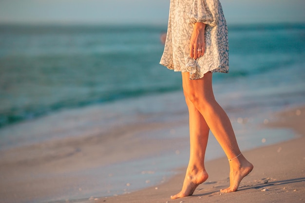 Foto sección baja de una mujer de pie en la playa