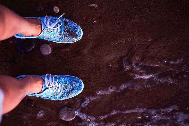 Foto sección baja de una mujer de pie en la playa