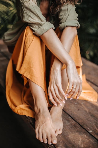 Foto sección baja de una mujer de pie en el suelo de madera