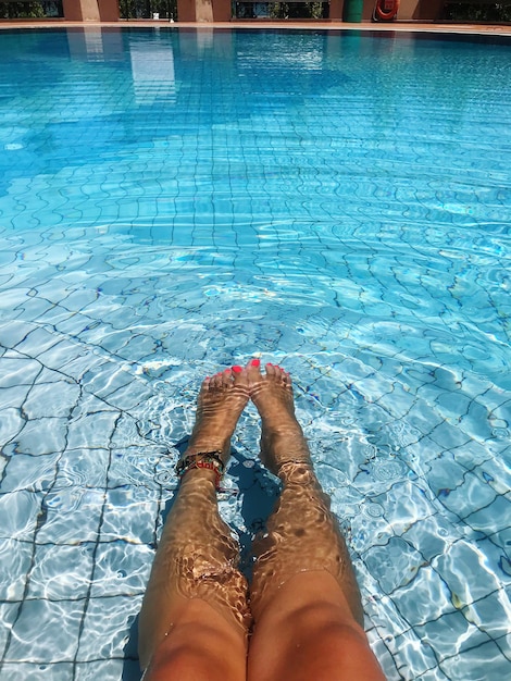 Foto sección baja de la mujer en la piscina