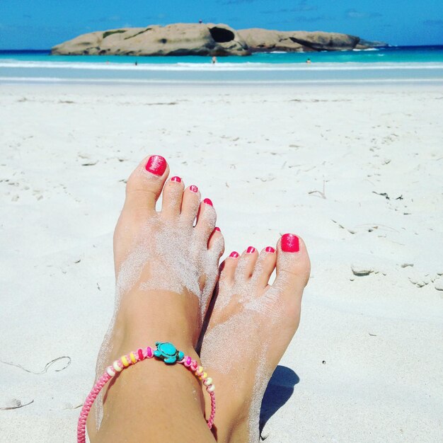 Foto sección baja de la mujer en la playa durante el verano