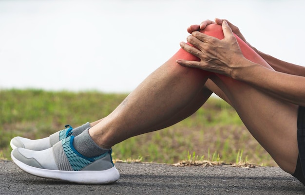 Foto sección baja de la mujer que sufre de dolor en la rodilla