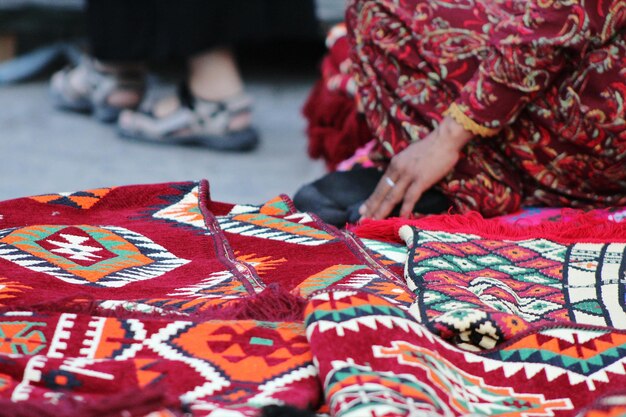Sección baja de la mujer que vende alfombras