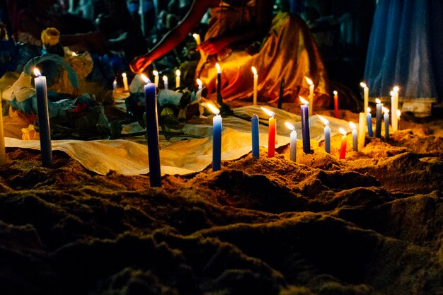 Foto sección baja de una mujer quemando una vela durante el festival de iemanja