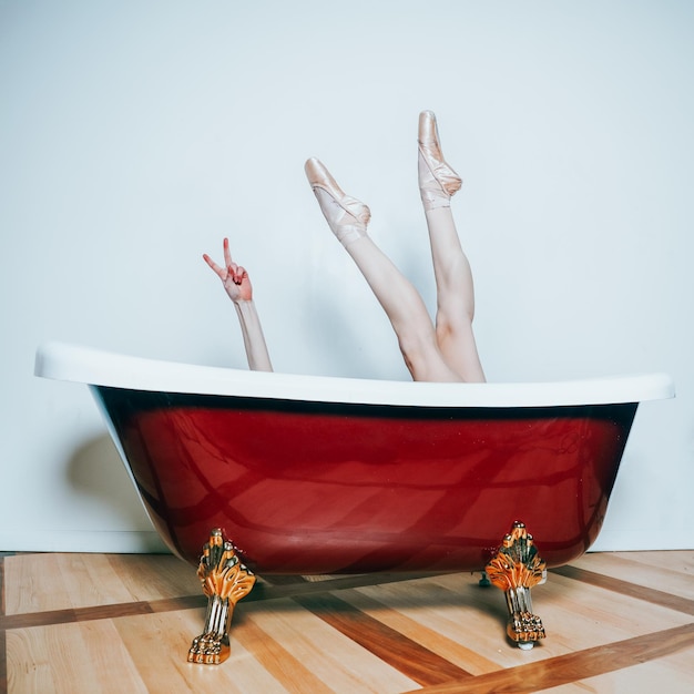 Sección baja de una mujer relajándose en la bañera