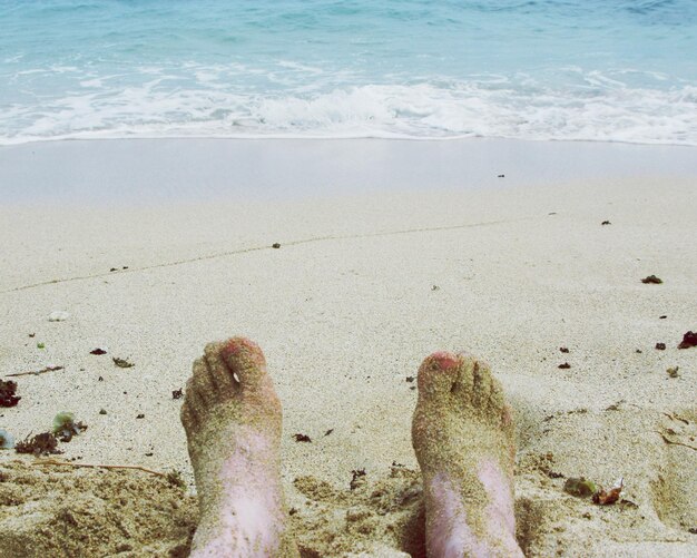 Foto sección baja de una mujer relajándose en la playa