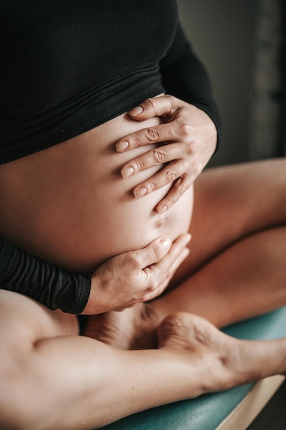 Sección baja de la mujer sentada en casa