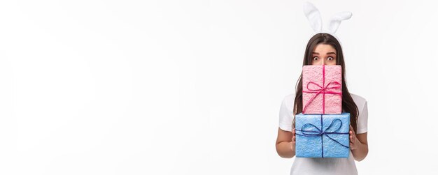 Foto sección baja de una mujer sosteniendo un regalo contra un fondo blanco