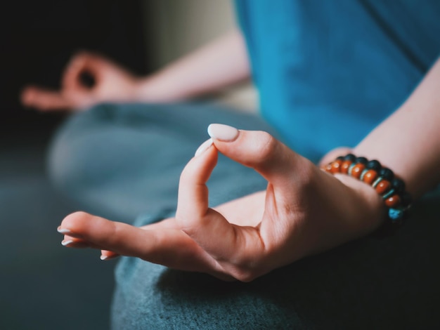 Sección baja de mujeres haciendo yoga en casa.
