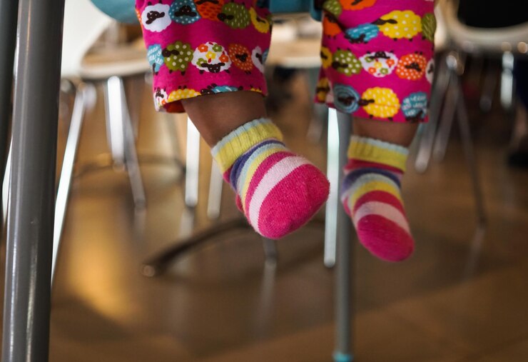 Foto sección baja de una niña que lleva calcetines en casa