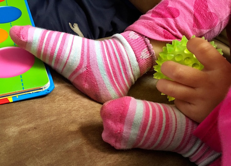 Foto sección baja de una niña que sostiene un juguete
