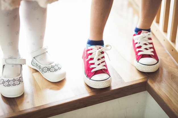 Sección baja de niños de pie en una mesa de madera