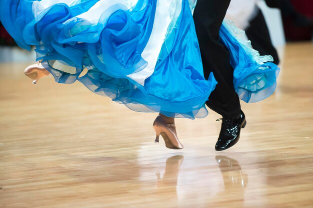 Sección baja de una pareja bailando en el suelo de madera dura