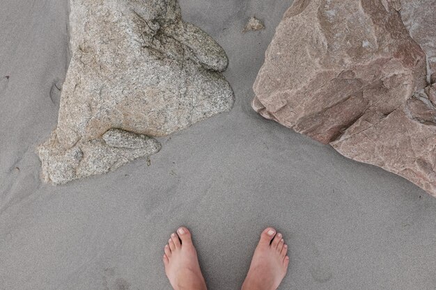 Foto sección baja de una persona en la arena de la playa