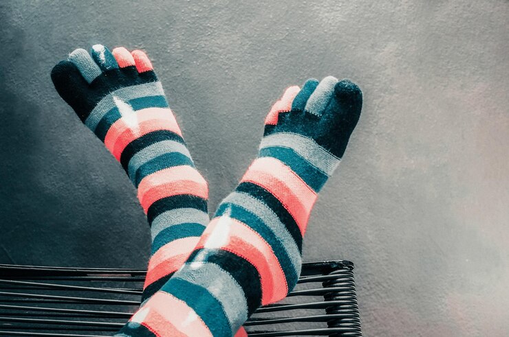Foto sección baja de una persona con calcetines contra la pared