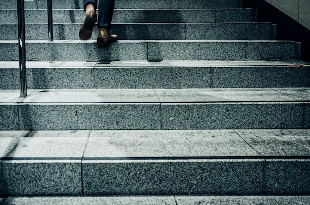 Sección baja de una persona caminando por escalones