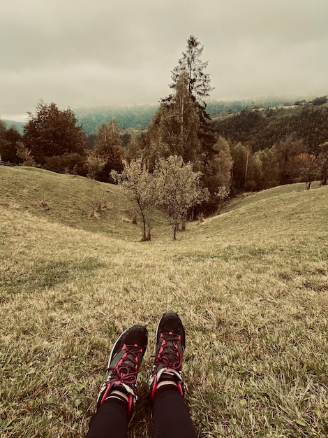 Foto sección baja de la persona en el campo contra el cielo