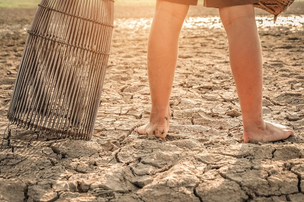 Foto sección baja de una persona de pie en un campo de sequía