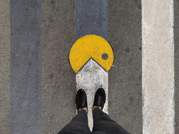 Sección baja de una persona de pie en la carretera