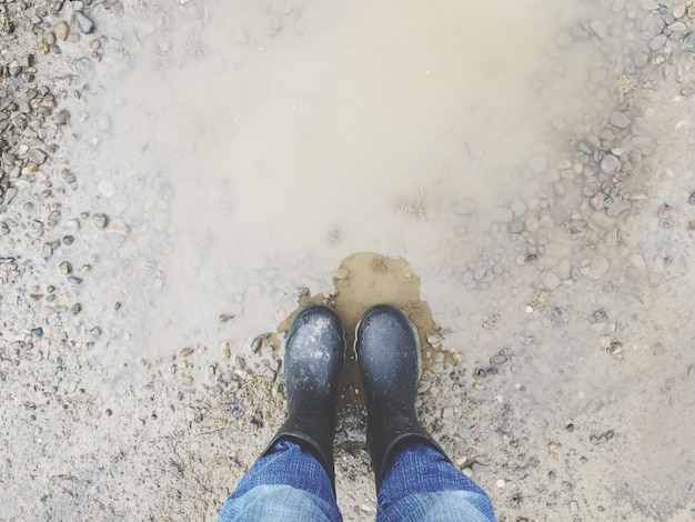 Foto sección baja de una persona de pie en un charco