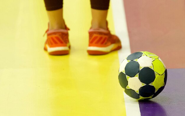 Foto sección baja de la persona de pie por la pelota en la cancha