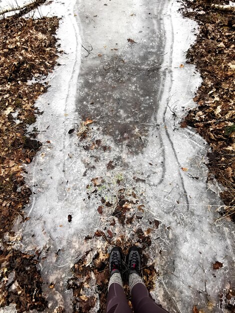 Foto sección baja de una persona de pie sobre el hielo