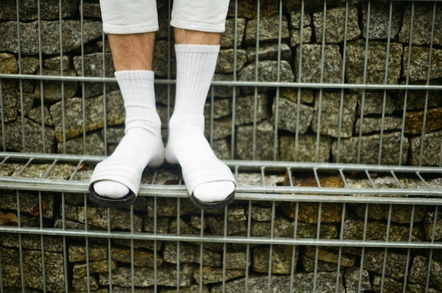 Foto sección baja de una persona de pie en la vía del ferrocarril.