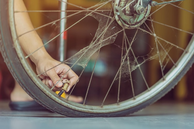 Sección baja de la persona que comprueba la rueda de la bicicleta