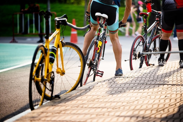 Sección baja de personas estacionando bicicletas en la carretera