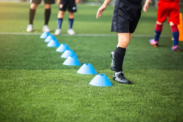 Sección baja de personas jugando al fútbol en el césped