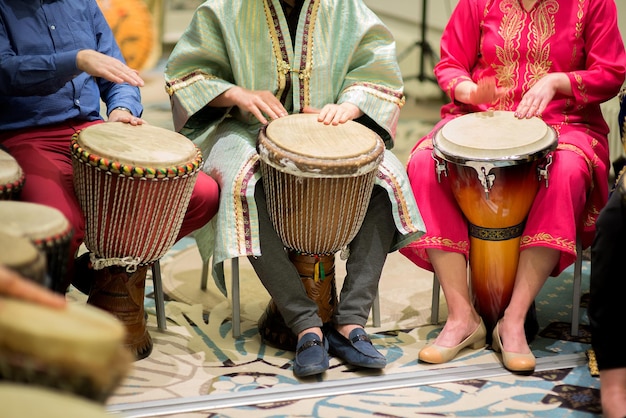 Sección baja de personas tocando djembes