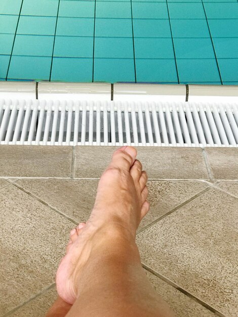 Sección baja de las piernas del hombre en la piscina