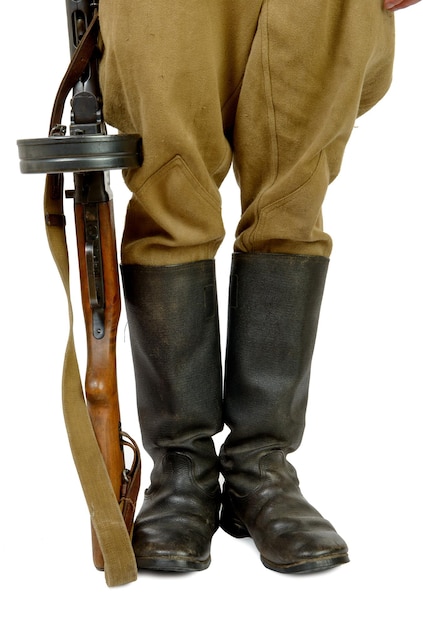Sección baja de un soldado del ejército sosteniendo un rifle contra un fondo blanco