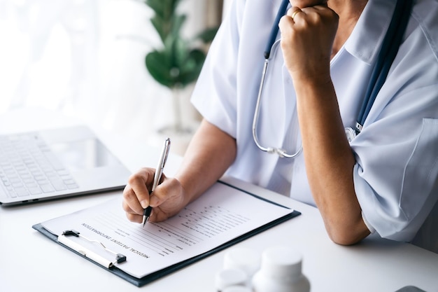 La sección intermedia de la doctora escribe una receta al paciente en la mesa de trabajo