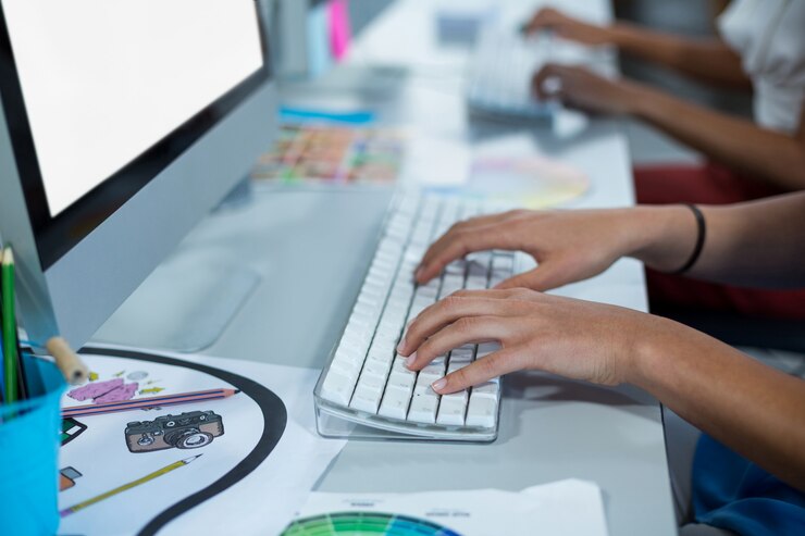 Foto sección intermedia de mujeres diseñadoras gráficas que trabajan en computadoras personales