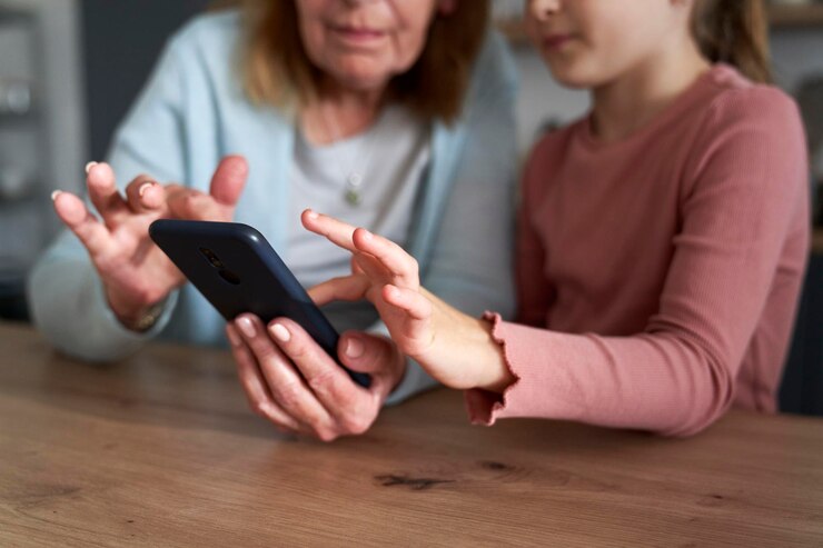 Foto sección media de la abuela y la nieta hablando en video llamada en casa